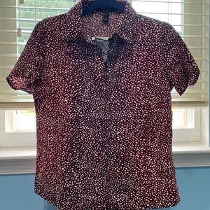 This is a short sleeve shirt in burgundy with a white dotted design.